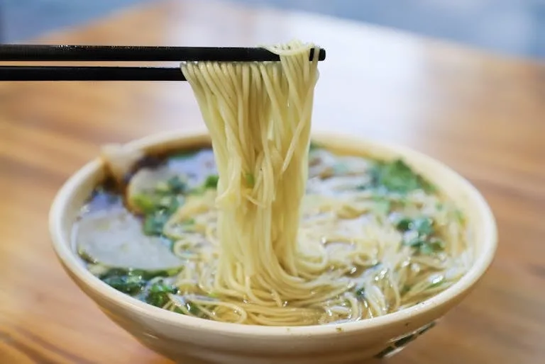 Un bol de ramen végétarien avec des nouilles et des baguettes