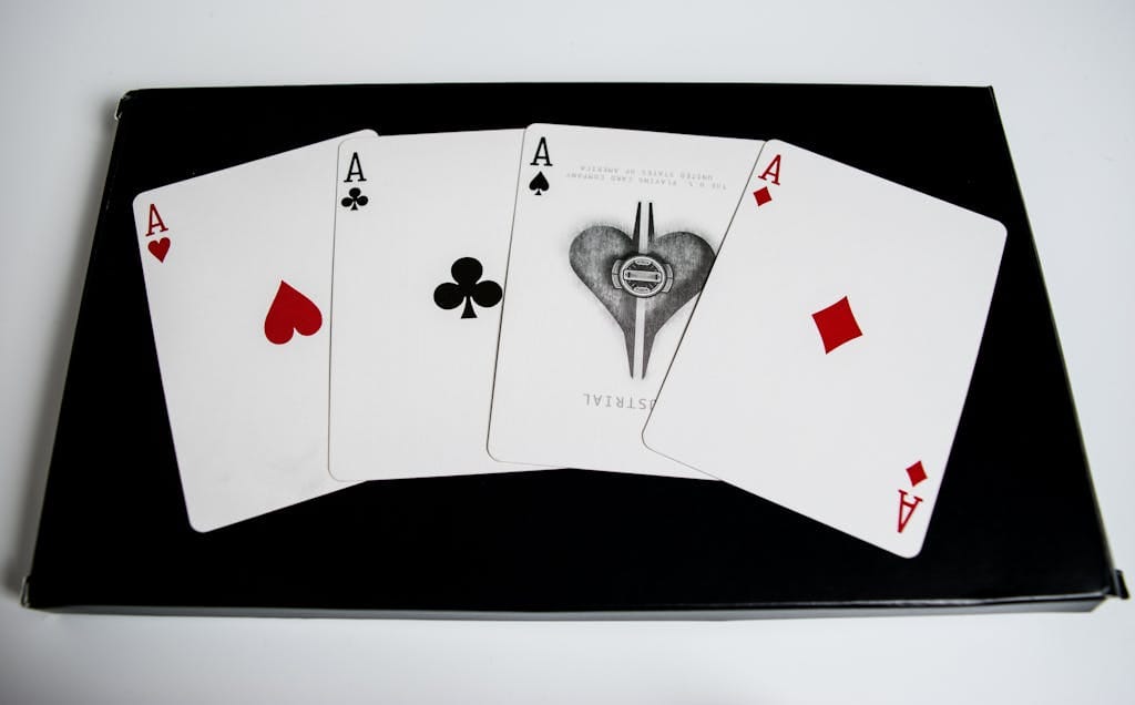 High-quality image of four aces from a deck of playing cards on a black surface.